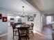 Dining room with decorative lights and hardwood floors open to the kitchen with white cabinets at 10929 Lassen Ct, Charlotte, NC 28214