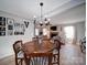 Dining room with hardwood floors and decorative light fixture open to the living room with a fireplace at 10929 Lassen Ct, Charlotte, NC 28214