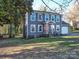 Two-story home with gray siding, a bright orange front door, attached garage, and a well-maintained lawn at 10929 Lassen Ct, Charlotte, NC 28214