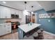 This is a modern kitchen with stainless appliances, white cabinets, an island, and attractive lighting at 10929 Lassen Ct, Charlotte, NC 28214