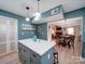 Open concept kitchen with island seating, wood floors, and modern lighting leading to the dining and living area at 10929 Lassen Ct, Charlotte, NC 28214