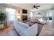 Inviting living room featuring a fireplace, hardwood floors, comfortable seating, and a ceiling fan at 10929 Lassen Ct, Charlotte, NC 28214