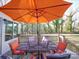 Outdoor deck with a patio table and umbrella surrounded by a lush green yard at 10929 Lassen Ct, Charlotte, NC 28214