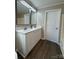 Bathroom with double vanity, white cabinets, framed mirrors and dark wood floors at 110 Amber Ln, Statesville, NC 28677