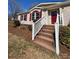 Inviting front entrance with brick steps, white railings, and a vibrant red front door at 110 Amber Ln, Statesville, NC 28677