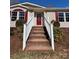 Inviting front entrance with brick steps, white railings, and a vibrant red front door at 110 Amber Ln, Statesville, NC 28677