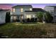 Backyard at dusk featuring a pergola-covered patio, perfect for outdoor living and entertainment at 11711 Royal Castle Ct, Charlotte, NC 28277