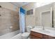 Bathroom featuring shower-tub combo with tiled walls, complementing fixtures and neutral tones at 11711 Royal Castle Ct, Charlotte, NC 28277