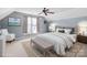 Stylishly staged bedroom, featuring a plush bed, accent chair, and a decorative rug over neutral carpet at 11711 Royal Castle Ct, Charlotte, NC 28277