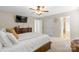 Large, neutral bedroom featuring a ceiling fan, many windows, and an ensuite bathroom at 11711 Royal Castle Ct, Charlotte, NC 28277