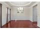 Elegant dining room with hardwood floors, tray ceiling, chandelier, and wainscoting at 11711 Royal Castle Ct, Charlotte, NC 28277