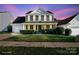 Attractive two-story home with manicured front lawn and traditional architectural details under a colorful sky at 11711 Royal Castle Ct, Charlotte, NC 28277