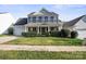 Inviting two-story home boasts a well-kept lawn, lush hedges, and an attached two-car garage at 11711 Royal Castle Ct, Charlotte, NC 28277