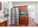 Modern kitchen features stainless steel refrigerator and appliances, next to custom wood cabinetry at 11711 Royal Castle Ct, Charlotte, NC 28277