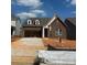 New construction home features a brick facade, attached garage, and a well-lit front entrance at 126 Goorawing Ln, Mooresville, NC 28115