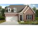 Charming brick and stone home featuring a two-car garage, dormer windows, and manicured landscaping at 126 Goorawing Ln, Mooresville, NC 28115