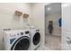 Functional laundry room with washer, dryer, storage baskets, and closet at 126 Goorawing Ln, Mooresville, NC 28115