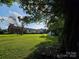 Large grassy backyard with mature tree, showing home's rear exterior and separate shed at 130 Scism Rd, Kings Mountain, NC 28086