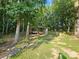 Property features an open metal storage area for equipment, nestled among mature trees at 130 Scism Rd, Kings Mountain, NC 28086