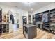 Spacious walk-in closet with custom shelving, center island, wood floors, and a door to the bathroom at 13546 W Highway 55 W Hwy, York, SC 29745