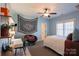 Bedroom with light-blue walls featuring a ceiling fan, white trim, shelves and a cozy chair at 152 Bay Shore Loop, Mooresville, NC 28117