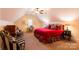 A spacious bedroom is furnished with patterned bedding, desk, and stylish chairs at 152 Bay Shore Loop, Mooresville, NC 28117