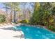 Backyard swimming pool with a built-in spa and surrounding mature trees for privacy at 152 Bay Shore Loop, Mooresville, NC 28117
