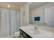 Well-lit bathroom featuring a shower with a leaf-patterned curtain, a mirror, and a sink at 15237 Red Canoe Way, Charlotte, NC 28278