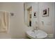 Stylish powder room with a modern sink, decorative mirror, and neutral color palette at 15237 Red Canoe Way, Charlotte, NC 28278