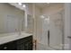 Clean bathroom featuring black vanity, single sink, and glass-enclosed shower at 15237 Red Canoe Way, Charlotte, NC 28278