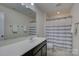 Bright bathroom featuring a shower with a blue-striped curtain, a mirror, and a white countertop at 15237 Red Canoe Way, Charlotte, NC 28278