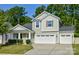Charming two-story home with attached two car garage, manicured lawn, and mature trees at 15237 Red Canoe Way, Charlotte, NC 28278