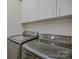 Laundry room featuring black front load washer and dryer with white upper cabinets at 15237 Red Canoe Way, Charlotte, NC 28278