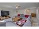 Expansive living room with a large sectional sofa, media center, and a ceiling fan at 15237 Red Canoe Way, Charlotte, NC 28278
