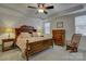 Comfortable main bedroom with hardwood furniture, tray ceiling, ceiling fan, and two windows at 15237 Red Canoe Way, Charlotte, NC 28278