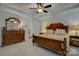 Well-lit bedroom with tray ceiling, wooden furniture, lamps, and neutral-colored carpet at 15237 Red Canoe Way, Charlotte, NC 28278