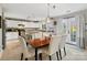 Bright dining area featuring white upholstered chairs, stylish lighting, and French doors leading to the backyard at 15320 Yellowstone Springs Ln, Charlotte, NC 28273