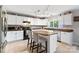 Well-lit kitchen featuring white cabinetry, a center island with seating, and tile flooring at 15320 Yellowstone Springs Ln, Charlotte, NC 28273