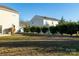 View of a backyard with green grass and shrubbery, adjacent to two-story home at 1612 Beleek Ridge Ln, Clover, SC 29710