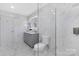 Modern bathroom featuring marble tiling, glass shower, and gray vanity with updated lighting at 1612 Beleek Ridge Ln, Clover, SC 29710
