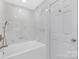 Sleek bathroom featuring marble walls and a modern tub with a glass door and updated hardware at 1612 Beleek Ridge Ln, Clover, SC 29710