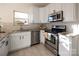 View of the kitchen's stainless steel appliances, white cabinets, and granite countertops at 1612 Beleek Ridge Ln, Clover, SC 29710