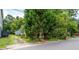 Exterior view of home showing gravel driveway and mature landscaping with shade trees at 1716 Umstead St, Charlotte, NC 28205