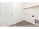 Functional laundry room with connections, shelving, door and durable flooring for easy maintenance at 200 J.P. Dr # 184P, Albemarle, NC 28001