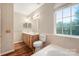 Well-lit bathroom with double sink vanity, tiled walls, and a large window above the bathtub at 2009 Whippoorwill Ln, Indian Trail, NC 28079