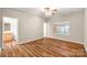 Bright bedroom featuring wood floors, ceiling fan, and ensuite bathroom access at 2009 Whippoorwill Ln, Indian Trail, NC 28079