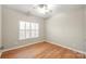 Bright bedroom features wood floors, ceiling fan, and a window providing natural light at 2009 Whippoorwill Ln, Indian Trail, NC 28079