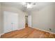 Cozy bedroom featuring wood floors, ceiling fan, a double-door closet, and bright natural light at 2009 Whippoorwill Ln, Indian Trail, NC 28079