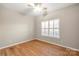 Bright bedroom featuring hardwood floors, ceiling fan and a window with shutter blinds at 2009 Whippoorwill Ln, Indian Trail, NC 28079