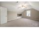 Angled ceiling bonus room with neutral carpet and window nook with bed at 2009 Whippoorwill Ln, Indian Trail, NC 28079